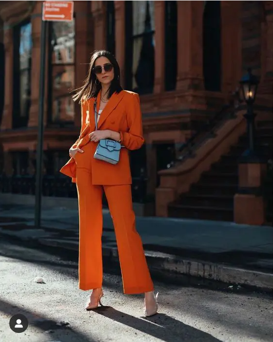 an orange power suit, a white top, nude shoes and a small blue bag are a great combo for a bold spring or summer look