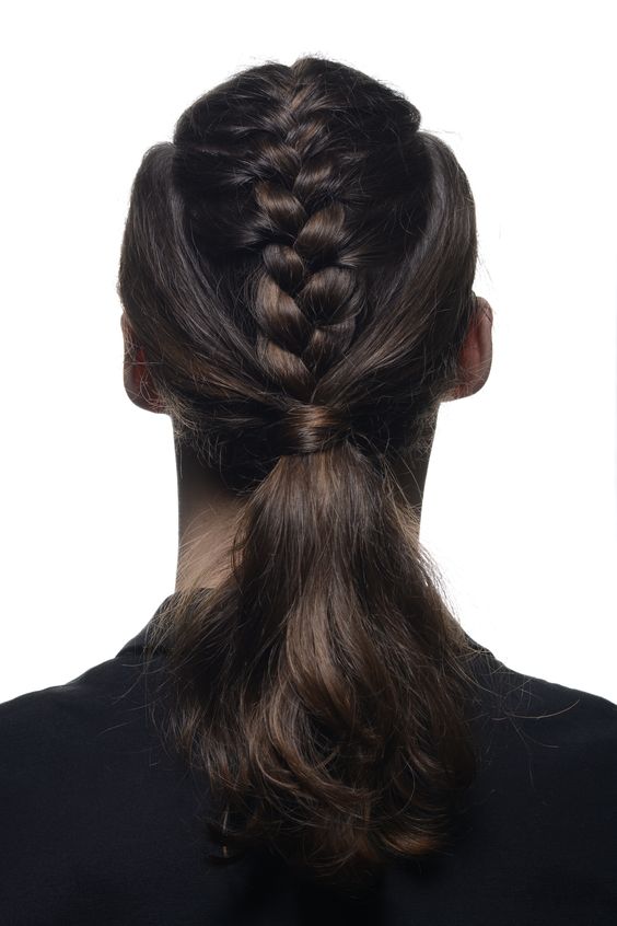 medium hair styled with a low ponytail and a braid on top is a cool and bold hairstyle with a Viking feel