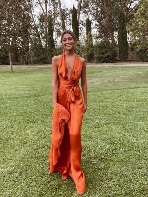 An orange maxi dress with thick straps and a sash is a bold idea for a colorful look at the prom.