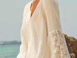 a simple white mini dress with bell lace sleeves and a V-neckline is a cool and cute coverup for the beach