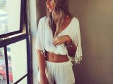 a white boho outfit with a crop top with bell sleeves and shorts wihth tassels plus a boho headpiece