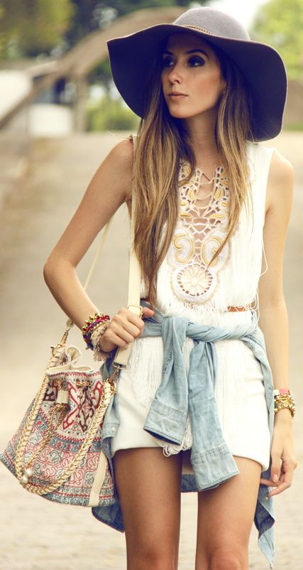 a white boho top and shorts, a denim jacket, a hat and a colorful embroidered bag