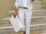 a white oversized shirt, white jeans, black heels, a metallic belt and a white clutch