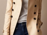 a classic short neutral double-breasted trench with black buttons is a stylish piece to wear this spring