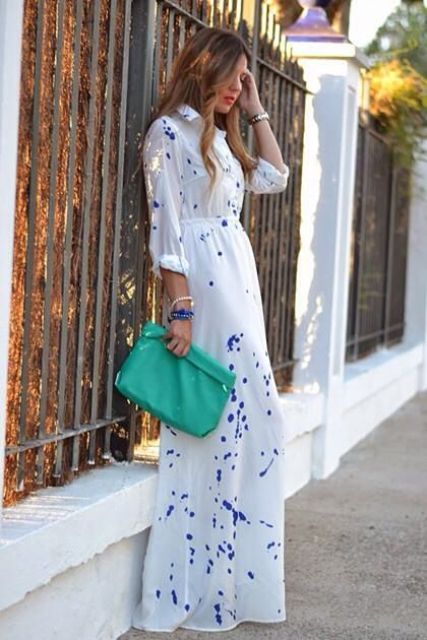 a white maxi dress with purple splashes, layered bracelets and an emerald clutch for a special occasion