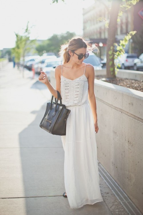 a white boho maxi dress with a lace and embellished bodice, spaghetti straps and a black tote