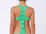 a bright neon green one piece swimsuit with lace on the back and open sides and shoulders