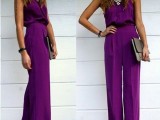 a bold fuchsia jumpsuit with a halter neckline, a statement necklace and a metallic clutch