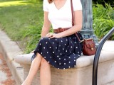 a retro-inspired look with a white top, a polka dot A-line skirt, brown flats, a bag and a belt