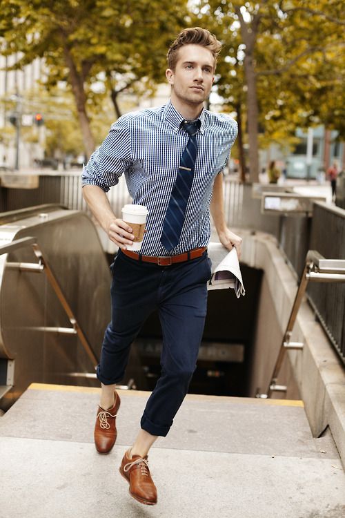 a stylish summer work look with navy cuffed pants, a blue printed shirt, a navy tie and brown shoes