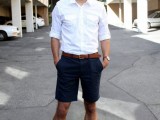 a light summer work look with long navy shorts, a white shirt with rolled up sleeves, brown shoes