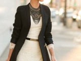 a creamy lace mini dress with your waist highlighted with a belt, a black blazer and black statement necklace plus a black clutch