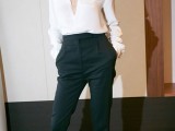 a classic monochromatic look with high waisted pants, high heels, a white blouse with a plunging neckline