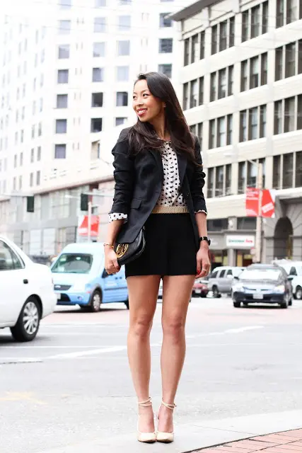 black mini shorts will highlight your legs, a polka dot top, a black blazer, creamy strappy shoes and a black clutch
